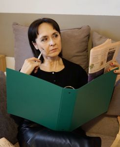 Monica Vitali riflette sulla gestione del bilancio familiare con appunti e quaderno Monica Vitali Il bilancio familiare e la riclassificazione dell'estratto conto